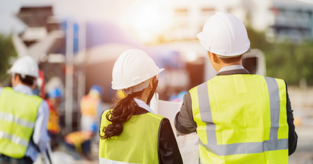 Two construction professionals reviewing plans together on an active job site